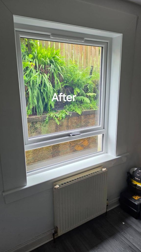 After: new white uPVC window above a radiator, looking out onto a planted garden wall