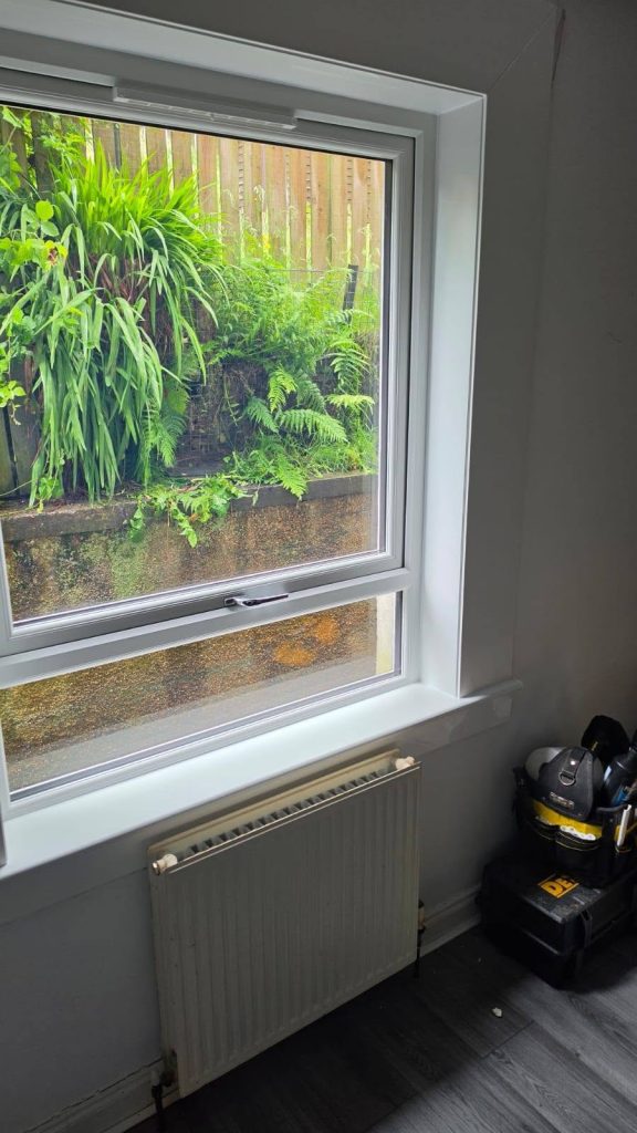 After: angled view of the new white uPVC window above the radiator
