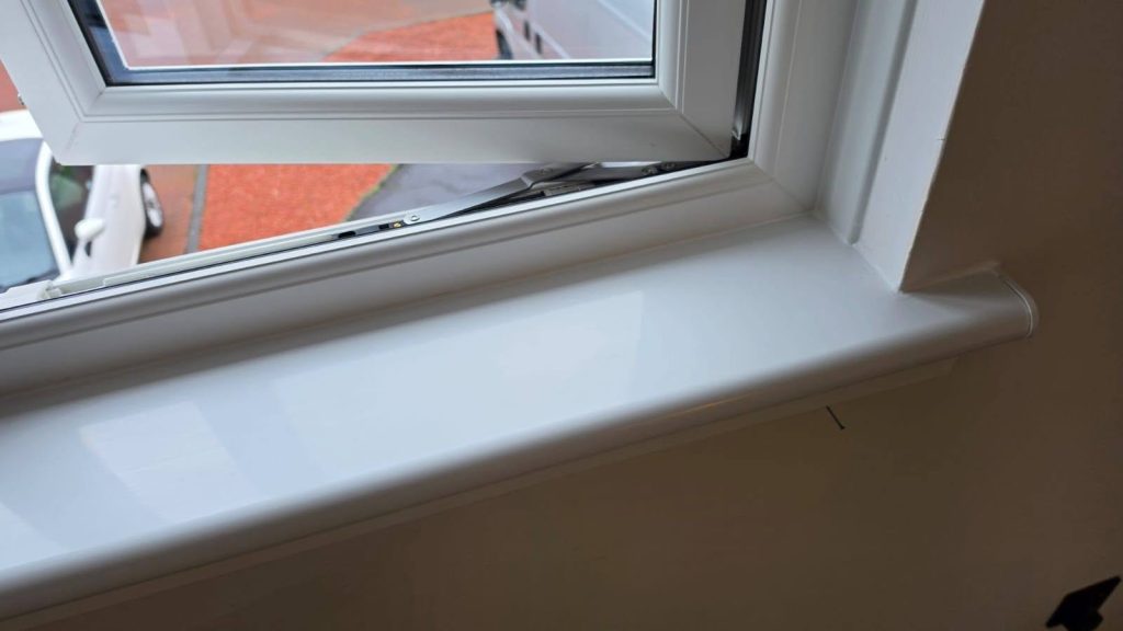 Close-up of the corner and sill of a newly fitted white uPVC window in Yoker